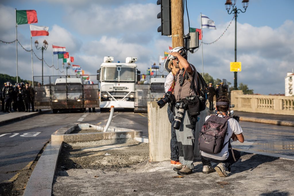 Journalisten bringen sich vor französischen Wasserwerfern und Gummigeschossen in Deckung