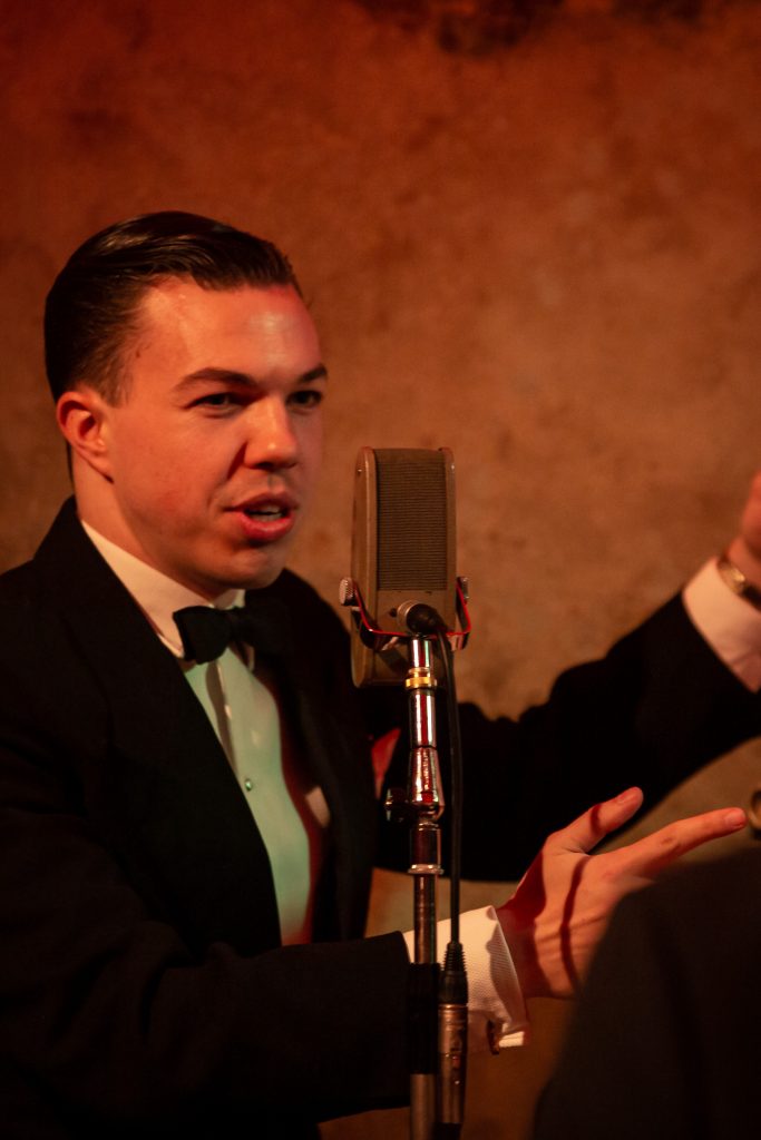 Ein Musiker spielt und singt im Stil der Goldene Zwanziger auf einer Mottoparty