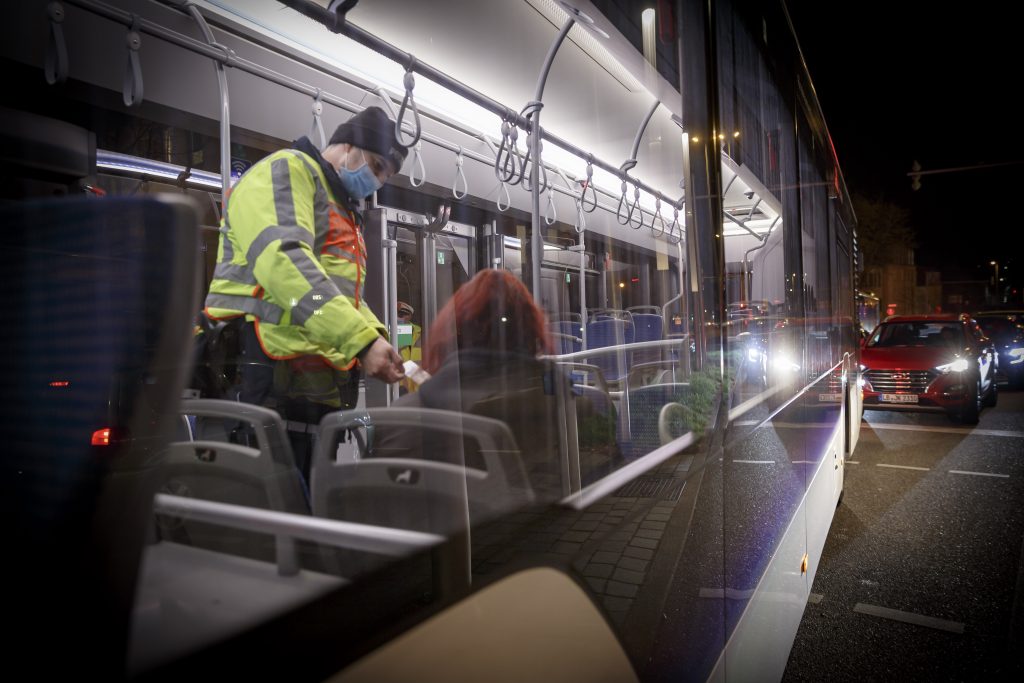 Ein Polizist kontrolliert die Insassin eines Stadtbusses in Ludwigsburg. Zu dem Zeitpunkt galt eine Ausgangssperre