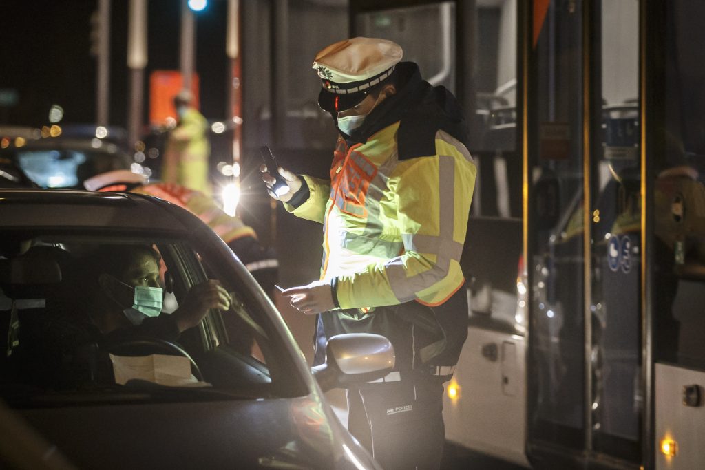 Ein Mann muss sich an einer Kontrollstelle zur Überwachung der Ausgangssperren während der Corona-Pandemie ausweisen