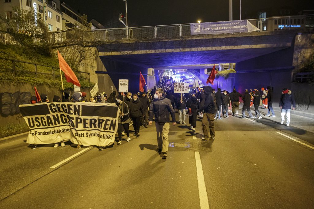 Linke Aktivistinnen und Aktivisten protestieren gegen die Ausganssperren während der Corona-Pandemie