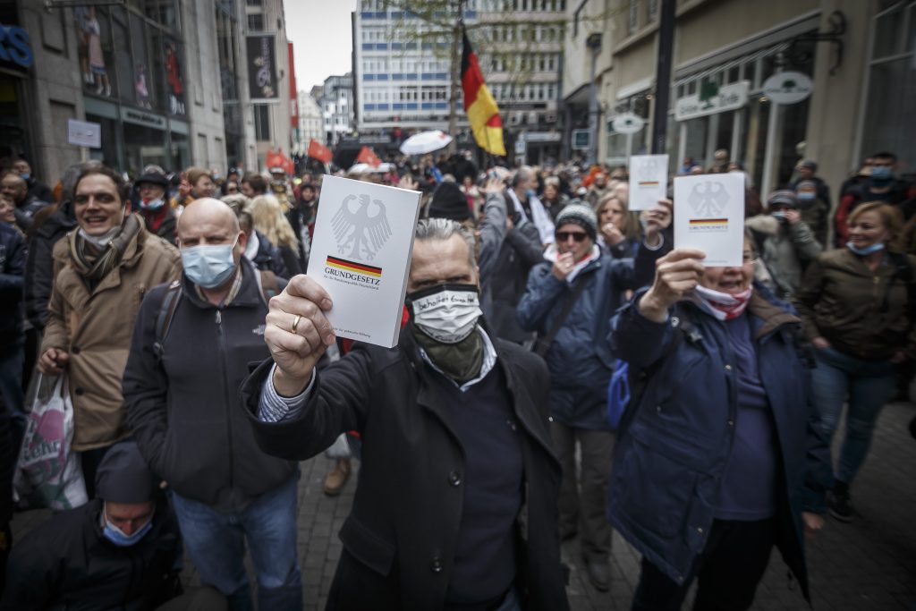 Protestierende aus dem Querdenken-Spektrum halten Ausgaben des Grundgesetzes vor sich