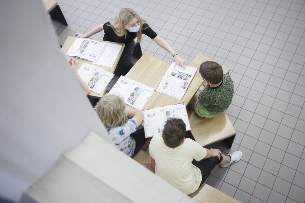 Ein Studentin unterstütz Schülerinnen und Schüler der 6. Klasse beim nachholen von Schulstoff