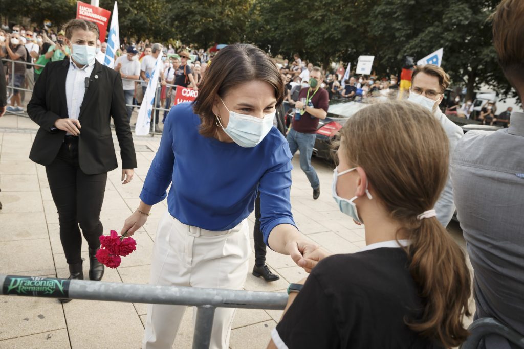 Annalena Baerbock spricht mit einem Mädchen, welches der Grünenpolitikerin Blumen geschenkt hat