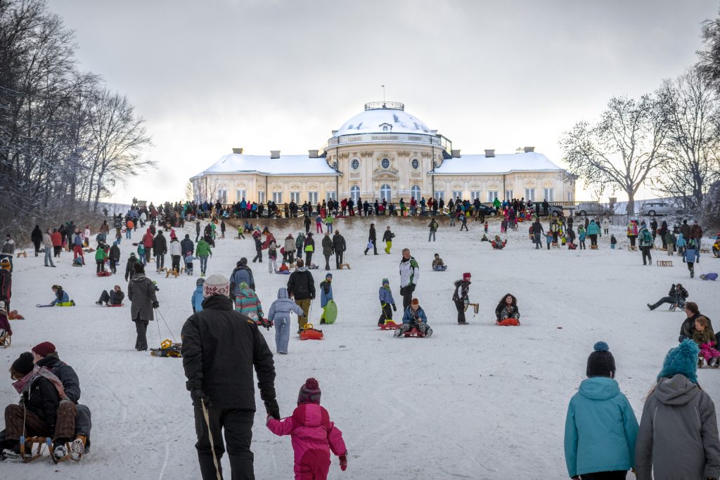 An einem schneereichen Wintertag wird die Wiese vor dem Schloss Solitude (Stuttgart) als Schlittenhang benutzt